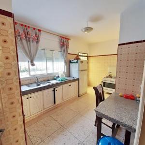 a kitchen with a table and a sink and a refrigerator at Rooms To book in Villa House at HostFamily in Rabat in Rabat