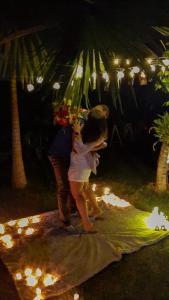 a man and a woman standing on a beach at night at Sítio Flora Rei in Holambra