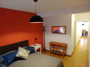 1 dormitorio con 1 cama y 1 mesa con lámpara en Departamento Centro Cívico en San Carlos de Bariloche