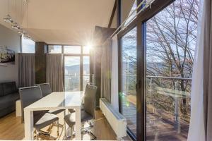 a dining room with a table and a large window at Apartament z widokiem na góry in Szklarska Poręba