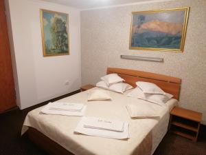 a hotel room with a bed with two towels on it at New Aosta Garden in Sinaia