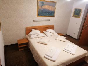 Una habitación de hotel con una cama con toallas blancas. en New Aosta Garden, en Sinaia
