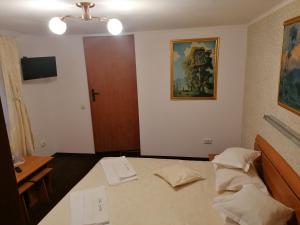 Un dormitorio con una cama y una puerta con una pintura en New Aosta Garden, en Sinaia