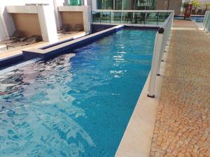 a swimming pool in a building with blue water at Flat Particular Jade Brasilia 1004 e 1006 Com Garagem in Brasilia