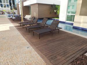 a row of chairs sitting next to a swimming pool at Flat Particular Jade Brasilia 1004 e 1006 Com Garagem in Brasília