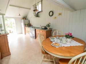 a kitchen with a wooden table and a table and chairs at Hayloft at Magnolia Lake in Exeter