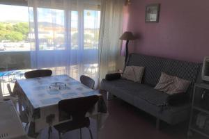 ein Wohnzimmer mit einem Tisch und einem Sofa in der Unterkunft Studio meublé 28m2 vue côté Balaruc centre et massif de la Gardiole in Balaruc-les-Bains