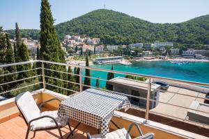 een balkon met een tafel en stoelen en uitzicht op het water bij Apartment Vista 2 in Dubrovnik