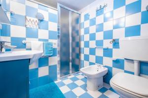 uma casa de banho azul e branca com um WC e um lavatório em Un' Altalena sul Mare - Accesso diretto in spiaggia em Marittima
