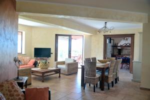 un soggiorno con tavolo e sedie di Panoramica Villa con Piscina sul Mare (Sanificata) a Cinisi