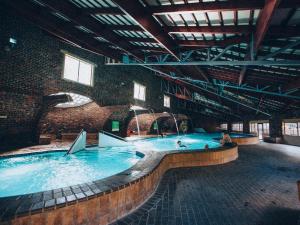 uma grande piscina interior num edifício de tijolos em ATKV Klein-Kariba em Bela-Bela