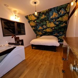 ein Schlafzimmer mit einem Bett und einem Wandgemälde in der Unterkunft Gite du Panty in Saint-Tricat