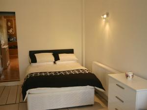 - une petite chambre avec un lit et une commode dans l'établissement Bryngower House, à Llanrhidian