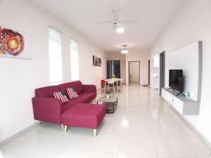 uma sala de estar com um sofá vermelho e uma televisão em New Vacation Homestay @Forest Valley em Kajang