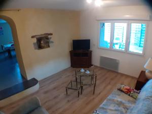 Saint-Paul-le-JeuneにあるGites les Eaux Clairesのソファとテレビのあるリビングルーム