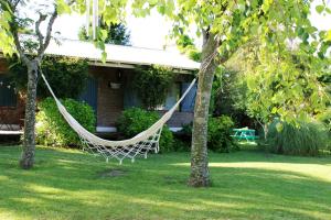 una hamaca colgando de dos árboles en un patio en Cabañas La Escondida en Tandil