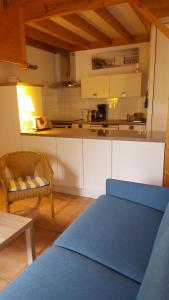 a kitchen with a blue couch in a room at Saint Martin in Saint-Martin-de-Ré