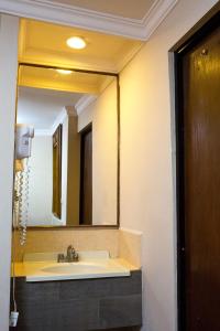 a bathroom with a sink and a large mirror at Hotel Royal Inn in Monclova