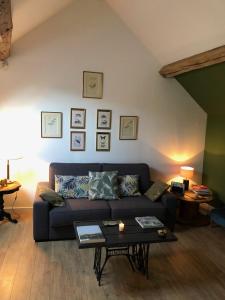 a living room with a couch and a table at A l'orée de la forêt in Recloses