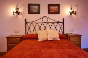 a bedroom with a large orange bed with two night stands at As Chivas in Redondela
