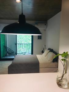 um quarto com uma cama e uma luz pendente em Studio II em Belén de Escobar