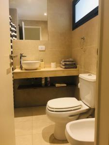 a bathroom with a toilet and a sink at Studio II in Belén de Escobar