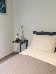 um quarto com uma cama com um candeeiro numa mesa lateral em Studio II em Belén de Escobar