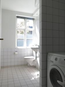 コペンハーゲンにあるApartmentInCopenhagen Apartment 1142の白いバスルーム(洗濯機、シンク付)