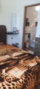 a leopard blanket on a bed in a room at Chale Sol in Caraguatatuba