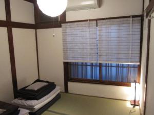 a room with a window and a bed with a lamp at Taito Ryokan in Tokyo