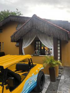 a yellow car parked in front of a building at Pousada In Bali - Maresias in Maresias