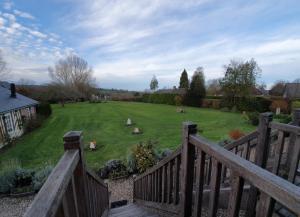 een uitzicht op een tuin vanaf een houten terras bij B&B - Le Clos aux Masques in Saint-Pierre-Azif