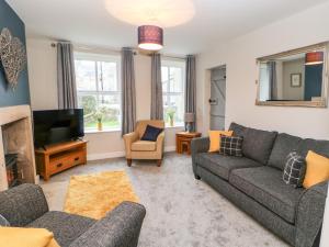 a living room with a couch and a tv at October Cottage in Barnard Castle