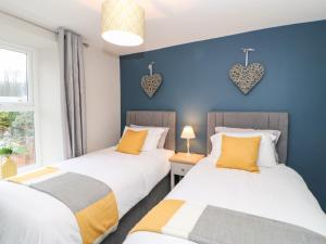 two beds in a room with hearts on the wall at October Cottage in Barnard Castle