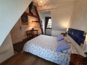 um quarto com uma cama com almofadas azuis em B&B - Le Clos aux Masques em Saint-Pierre-Azif