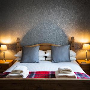 a bedroom with a bed with two towels on it at The Bellachroy Hotel in Dervaig