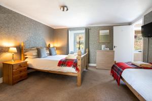 a large bedroom with two beds and a bathroom at The Bellachroy Hotel in Dervaig