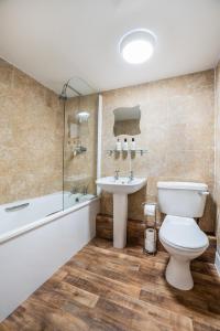 a bathroom with a toilet and a sink and a tub at The Bellachroy Hotel in Dervaig