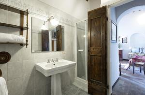 a bathroom with a sink and a shower and a mirror at Villa Serena & Dépendances in Cortona