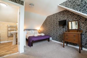 a bedroom with a bed and a sink and a mirror at The Bellachroy Hotel in Dervaig