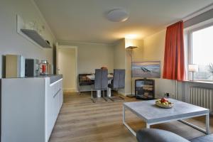 Una cocina y una sala de estar con una mesa y una sala de estar. en Braderuper Heide, en Braderup