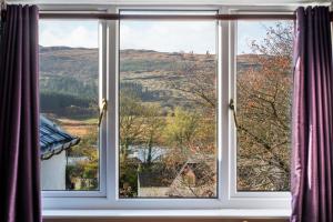 a window with a view of a mountain view at The Bellachroy Hotel in Dervaig