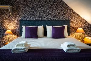 a bedroom with a bed with towels on it at The Bellachroy Hotel in Dervaig