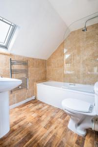 a bathroom with a tub and a toilet and a sink at The Bellachroy Hotel in Dervaig