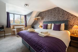 a bedroom with a large bed with purple sheets at The Bellachroy Hotel in Dervaig