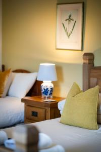 a room with two beds and a lamp on a table at The Bellachroy Hotel in Dervaig