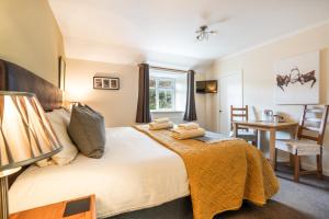 a bedroom with a large bed with a table and chairs at The Bellachroy Hotel in Dervaig