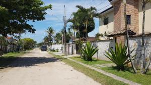 una strada vuota con una casa e palme di Casa na praia do Indaia piscina, bilhar, 5 quartos e vista a Bertioga