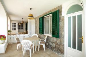 una sala da pranzo con tavolo, sedie e finestra di Appartamenti Baia di Citara a Ischia