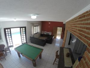 een woonkamer met een pooltafel en een bank bij Casa na praia do Indaia piscina, bilhar, 5 quartos e vista in Bertioga